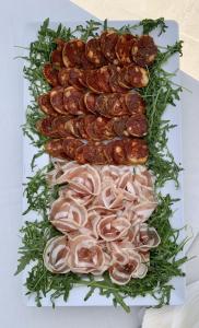a plate of food with meat and onions at HOTEL MERCURIO SUL MARE - Fish restaurant and private beach in Capo Vaticano