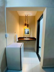 a kitchen with a white refrigerator and a sink at Hotel e Pousada Canto Mágico in Maresias