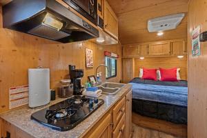 una cocina con fregadero y una cama en una casa pequeña en JT Village Campground - Sun Ray, en Joshua Tree