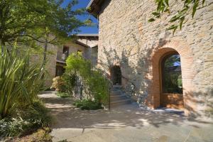a brick building with a wooden door and a staircase at Il Borgo - 1711 Luxury Guest House in Arlate
