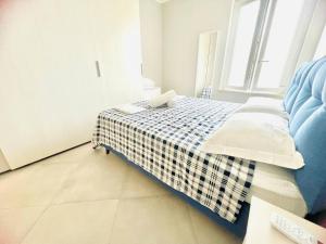 サンレモにあるSuite LEI - Sanremoのベッドルーム1室(チェック入りの毛布付きのベッド1台付) +9枚の写真