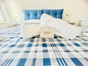 a bed with a blue and white blanket and pillows at Suite LEI - Sanremo in Sanremo