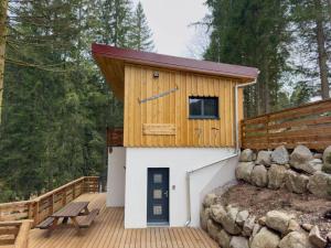 une petite cabine avec un toit en bois sur une terrasse en bois dans l'établissement Le Refuge perché du saut de la bourrique SPA Gérardmer, à Gérardmer