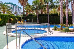 uma piscina com palmeiras num resort em AMBARBEACH sea view apartment em Calpe