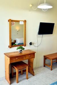 Habitación con mesa de madera y espejo. en BELLA CASA KOLYMPIA en Kolimbia