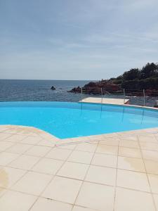 una piscina con l'oceano sullo sfondo di Studio calme vue mer pieds dans l'eau a Saint-Raphaël
