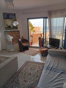 un soggiorno con divano e vista su un balcone di Studio calme vue mer pieds dans l'eau a Saint-Raphaël Altre 6 foto