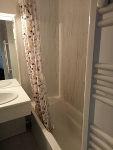 a bathroom with a tub and a sink and a shower at Studio calme vue mer pieds dans l'eau in Saint-Raphaël