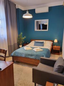 una camera blu con un letto e un divano di Hotel Staropolska a Tomaszów Lubelski
