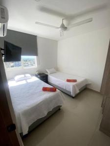 a room with two beds and a flat screen tv at Exclusivo apto / norte de valledupar hasta para 12 in Valledupar