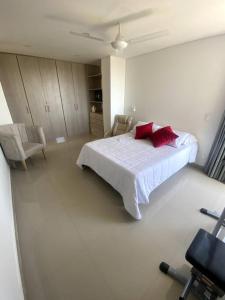 a white bedroom with a bed and two chairs at Exclusivo apto / norte de valledupar hasta para 12 in Valledupar