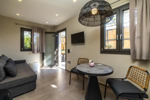 a living room with a couch and a table and chairs at Villa Dimitra - Saint Nikolas Retreat in Faraklata