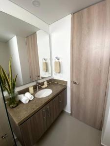 a bathroom with a sink and a large mirror at Exclusivo apto / norte de valledupar hasta para 12 in Valledupar