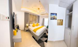 a bedroom with a large bed and yellow pillows at The Gibs Hotel Limited in Port Harcourt +16 photos