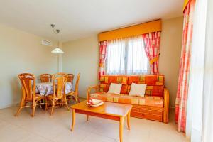 uma sala de estar com um sofá, uma mesa e cadeiras em AMBARBEACH sea view apartment em Calpe