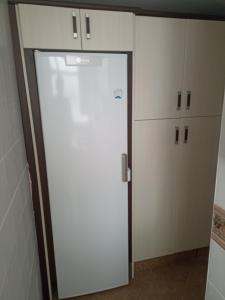 cocina con nevera blanca y armarios en Apartamento Bajo en Valdelagrana, Primera Línea de Playa, en El Puerto de Santa María 11 fotos más