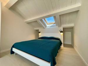 a bedroom with a bed with a blue comforter and a window at Casa Roma in Levanto