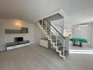 a living room with a staircase and a green table at Casa Roma in Levanto