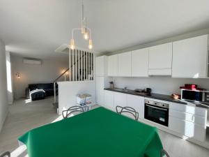 a kitchen with a green table and white cabinets at Casa Roma in Levanto