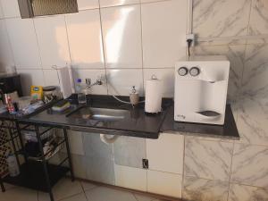a kitchen counter with a sink and a coffee maker at SUÍTE Princípio in Vila Velha