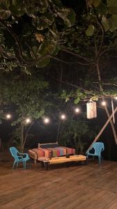 a patio with two beds and two chairs and lights at Private Beach with a Jungle Loft in Palomino