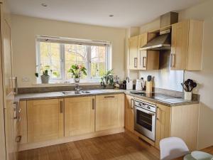 a kitchen with wooden cabinets and a sink and a window at Whitebeam in Camber