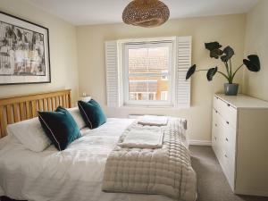 a bedroom with a white bed with a window at Whitebeam in Camber