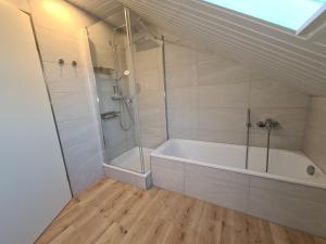 uma casa de banho com um chuveiro e uma banheira em Heimathafen em Wilhelmshaven