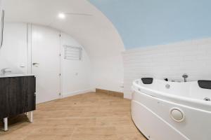 a white bathroom with a tub and a sink at El triangulo del Arte - Jacuzzi in Madrid