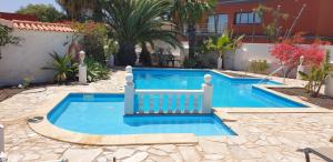 una piscina en un patio con una casa en Villa Océano mit privatem beheiztem Pool, vollklimatisiert und Meerblick, en Parque Holandes
