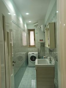 baño pequeño con lavadora y lavamanos en Al primo piano 22, en Castrovillari