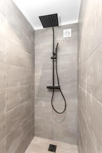 a shower with a shower head in a bathroom at Spacious, Cozy & Family Friendly House in Reykjavík