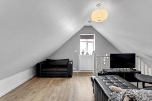 a living room with a couch and a tv at Spacious, Cozy & Family Friendly House in Reykjavík