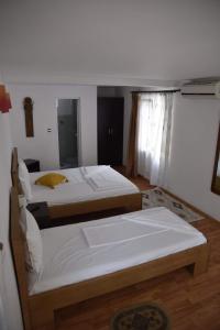 two twin beds in a room with a mirror at Pensiunea sellina in Sulina