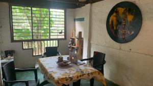 a dining room with a table and chairs and a painting at Private Beach with a Jungle Loft in Palomino