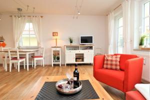 uma sala de estar com uma cadeira vermelha e uma mesa em Wohnpark Strandstraße App 12 em Wustrow