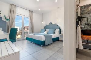 a bedroom with a blue bed and a balcony at Maison Etoile in Piano di Sorrento