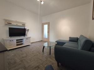 a living room with a couch and a tv at Apartman Mirna in Betina
