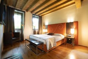 a bedroom with a bed and a desk and a chair at Il Borgo - 1711 Luxury Guest House in Arlate
