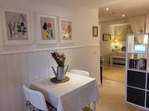 a dining room with a table with a vase of flowers on it at "COZY LOFT", TERRACE, PARKING and SWIMMING POOL in Málaga