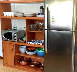 a kitchen with a stainless steel refrigerator and a microwave at HARE O MINI hasta 12 personas in Hanga Roa