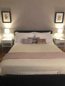 1 dormitorio con 1 cama grande y 2 lámparas en Repubblica90 eleganza e confort, en Parma