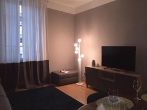 sala de estar con TV de pantalla plana y sofá en Repubblica90 eleganza e confort, en Parma