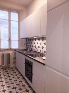 a kitchen with white cabinets and a stove top oven at Repubblica90 eleganza e confort in Parma