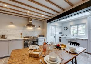 a large kitchen with a wooden table and chairs at Peacock Cottage in Holt