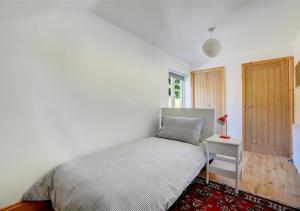 Schlafzimmer mit einem Bett und einer Holztür in der Unterkunft Rose Cottage in Stiffkey