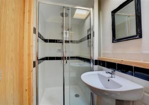 ein Badezimmer mit Glasdusche und Waschbecken in der Unterkunft Rose Cottage in Stiffkey + 9 Fotos