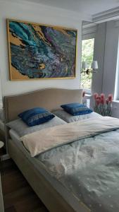 łóżko z 2 niebieskimi poduszkami w sypialni w obiekcie Apartment in the heart of Bialystok w mieście Białystok