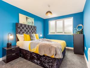 a blue bedroom with a bed and a window at Pass the Keys Central One bed apartment in Nottingham