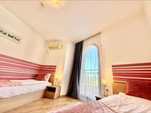 a bedroom with two beds and a window at Sea View Apartments - Aheloy in Ravda +52 photos